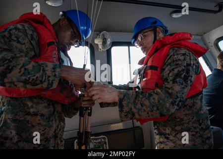 221008-N-CM110-1032 SÜDCHINESISCHES MEER (OKT 8, 2022) – U.S. Marine Corps Lance CPL. Nezechaven, aus New York, links, und U.S. Marine Corps Sgt. Fernando Martinez aus Orland Hills, Illinois, beide der Marine Expeditionary Unit (MEU) von 31. zugeordnet, montiert während einer Trainingsentwicklung im Südchinesischen Meer am 8. Oktober 2022 Kommunikationsgeräte in einem 11 Meter langen, aufblasbaren Boot mit starrem Rumpf (RHIB). Tripoli ist im Einsatzgebiet der US-Flotte von 7. tätig, um die Interoperabilität mit Verbündeten und Partnern zu verbessern und als einsatzbereite Einsatztruppe für den Frieden und die Aufrechterhaltung der Stabilität in der Indo zu dienen Stockfoto