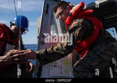 221008-N-CM110-1058 SÜDCHINESISCHES MEER (OKT 8, 2022) – U.S. Marine Corps Lance CPL. Nezechaven, aus New York, links, und U.S. Marine Corps Sgt. Fernando Martinez aus Orland Hills, Illinois, beide der Marine Expeditionary Unit (MEU) von 31. zugeordnet, montiert während einer Trainingsentwicklung im Südchinesischen Meer am 8. Oktober 2022 Kommunikationsgeräte in einem 11 Meter langen, aufblasbaren Boot mit starrem Rumpf (RHIB). Tripoli ist im Einsatzgebiet der US-Flotte von 7. tätig, um die Interoperabilität mit Verbündeten und Partnern zu verbessern und als einsatzbereite Einsatztruppe für den Frieden und die Aufrechterhaltung der Stabilität in der Indo zu dienen Stockfoto