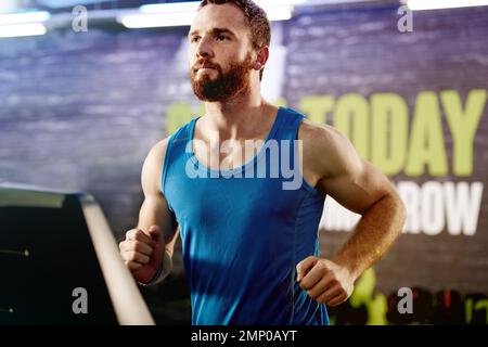 Halte deinen Kopf oben und dein Herz stark. Ein junger Mann, der auf einem Laufband trainiert. Stockfoto