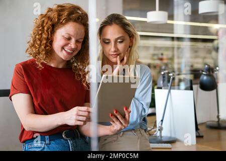 Porträt glücklicher junger Geschäftsfrauen, lächelnde Designer bei der Zusammenarbeit im Büro Stockfoto