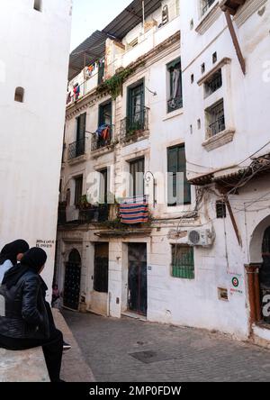 Algerische Frauen sitzen vor einem alten Gebäude in der Kasbah, Nordafrika, Algier, Algerien Stockfoto