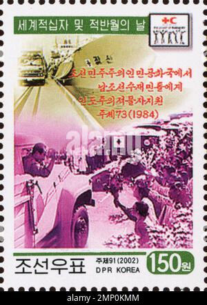 Nordkoreanische Briefmarke aus dem Jahr 2002 zur Erinnerung an die humanitäre Hilfe, die 1984 für südkoreanische Flutopfer zum Welttag des Roten Kreuzes geleistet wurde. Stockfoto
