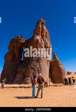 Touristen, die die Felsschnitzerei La Vache qui pleure, Nordafrika, Erg Admer, Algerien besuchen Stockfoto