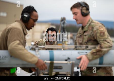 USA Air Force Staff Sgt. Anhre Bourgeois (links), ein 356. Aircraft Maintenance Unit Weapons Load Crew Chief, und Senior Airman Dylan Stratton (rechts), ein 356. Aircraft Maintenance Unit Weapons Load Crew Mitglied, leiten ein AIM-120 während eines Laderwettbewerbs auf dem Eielson Air Force Base, Alaska, 7. Oktober 2022. Das ganze Jahr über finden Ladungswettkämpfe statt, um die Waffenladungsteams auf Kriegslasten vorzubereiten. Stockfoto