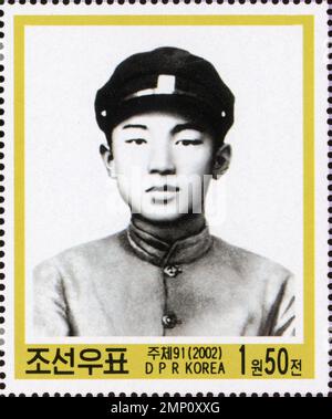 Nordkoreanische Briefmarke aus dem Jahr 2002 mit einem Porträt eines jungen Kim Il-gesungen in Uniform. Stockfoto