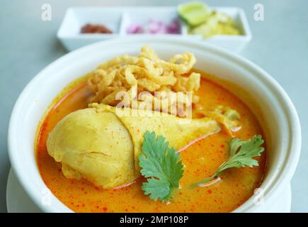 Nahaufnahme des köstlichen Chicken Khao Soi, einer beliebten nordthailändischen Kokosnuss-Curry-Nudelsuppe Stockfoto