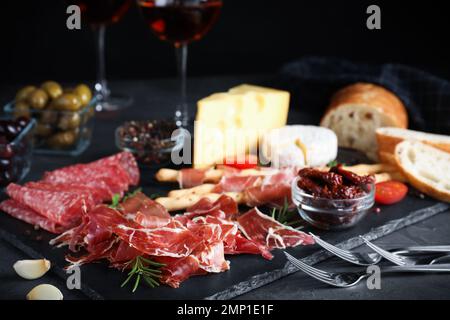 Leckerer frischer Prosciutto auf grauem Tisch serviert Stockfoto