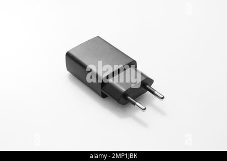 Schwarzer Netzwerkadapter 220V USB-Ladevorgang auf weißem Hintergrund Nahaufnahme Stockfoto