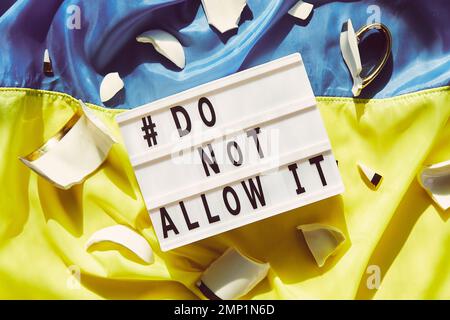 Die ukrainische Flagge mit zerbrochenen Cu-Stücken und Text lässt dies nicht zu. Beenden Sie den Krieg in der Ukraine. Das Konzept „Stay with Ukraine“. Stockfoto