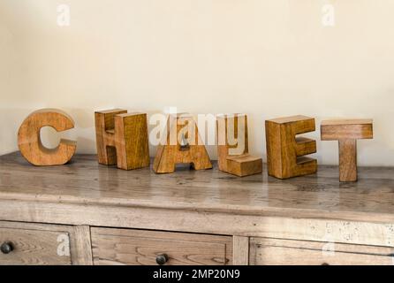 Holzwürfel, die das Wort Chalet bilden, auf Möbeln platziert und zur Dekoration verwendet. Stockfoto