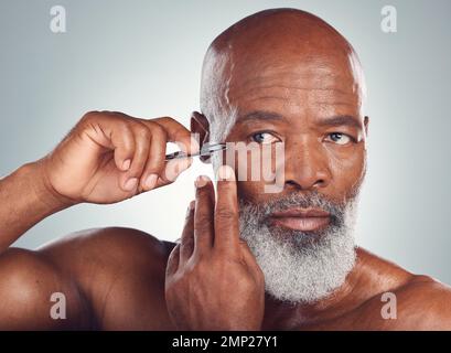 Pflege, Hautpflege und schwarzer Mann mit einer Pinzette zur Haarentfernung isoliert auf Studiohintergrund. Reinigung, Schönheit und Gesicht eines afrikanischen Seniors Stockfoto