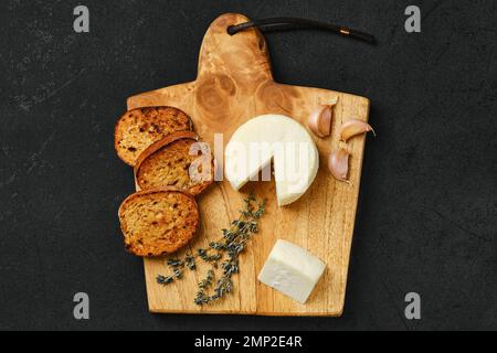 Blick von oben auf den kleinen Ziegenkäsekopf und Knoblauch-getoastetes Brot Stockfoto