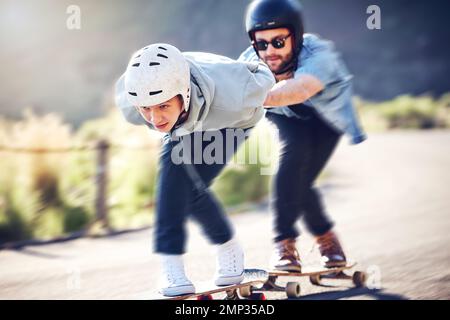 Schlittschuhlaufen, Longboard und Freunde, die schnell auf einer Straße fahren, mit Skateboard und Helm bergab fahren, um die Sicherheit zu gewährleisten. Extremsport, Geschwindigkeit und Menschen oder Stockfoto