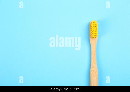 Zahnbürste aus Bambus auf hellblauem Hintergrund, Draufsicht. Platz für Text Stockfoto