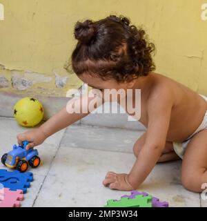 Süßer kleiner Junge Shivaay Sapra auf dem Balkon zu Hause im Sommer, süßer kleiner Junge Fotoshooting bei Tageslicht, kleiner Junge genießt zu Hause während Pho Stockfoto