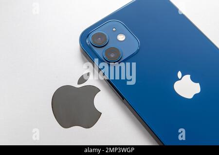Nach London. GROSSBRITANNIEN - 01.29.2023. Das Apple Company-Symbol auf der Rückseite eines MacBooks mit einem iPhone oben. Stockfoto