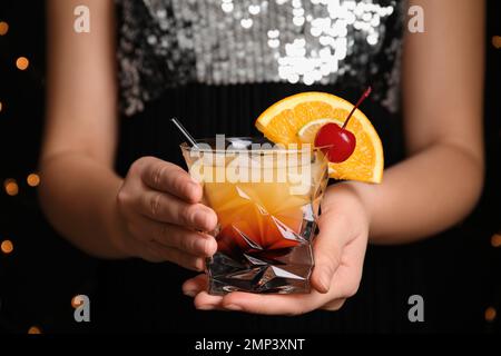 Frau mit einem Glas Tequila Sunrise, Nahaufnahme. Köstlicher alkoholischer Cocktail Stockfoto