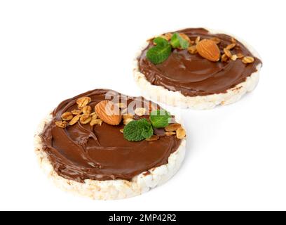 Gepufferte Reiskuchen mit Schokoladenaufstrich, Nüssen und Minze isoliert auf weiß Stockfoto