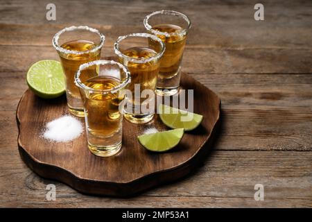 Mexikanische Tequila-Shots, Limette und Salz auf einem Holztisch Stockfoto