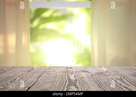 Leerer Holztisch vor dem Fenster. Sonniger Morgen Stockfoto