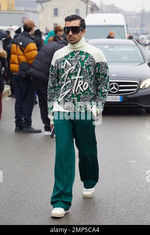 MAILAND, ITALIEN - 15. JANUAR 2023: Mann mit grüner Hose und Etro-Rollkragenpullover vor der Etro-Modenschau, Mailand Fashion Week Street Style Stockfoto