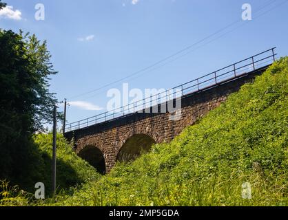 Die alte Eisenbahnbrücke ist aus Stein gebaut. Historisches Gebäude verwendet Stockfoto