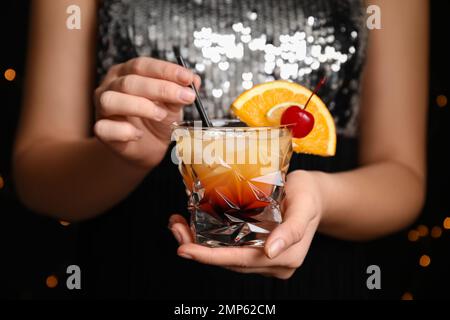 Frau mit einem Glas Tequila Sunrise, Nahaufnahme. Köstlicher alkoholischer Cocktail Stockfoto