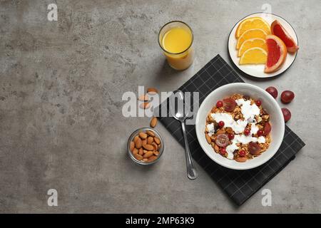 Leckeres, gesundes Frühstück serviert auf grauem Tisch, flach liegend. Platz für Text Stockfoto