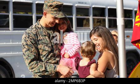 USA Captain Joshua Foster, der 22. Marine Expeditionary Unit (MEU) zugeteilt, trifft sich mit seiner Frau und seinen Töchtern während eines Homecoming an Bord von Camp Lejeune am 9. Oktober 2022. Marines und Matrosen, die der 22. MEU zugewiesen wurden, kehrten nach einem siebenmonatigen Einsatz mit der Kearsarge Amphibious Ready Group in den USA nach Hause zurück Marine 6. Flottengebiet. (USA Marinekorps Fotos von Staff Sgt. Marcela Diazdeleon) Stockfoto