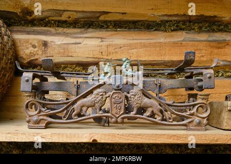 Klassische Metallskalen im Retro-Stil auf dem Hintergrund einer Holzwand aus Baumstämmen Stockfoto