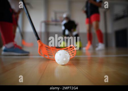 Nahaufnahme von Unihockey-Stock und Ball während des Unihockey-Spiels einer Frau im Fitnessstudio. Stockfoto