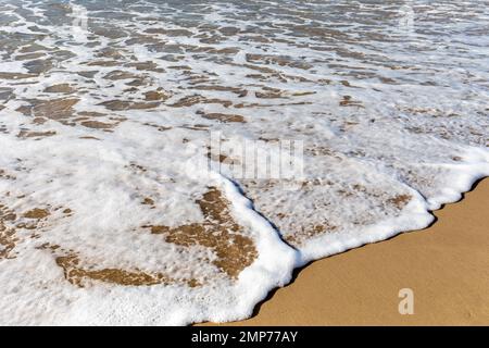 Schäumende Wellen brechen sanft auf eine Sandstrand-Nahaufnahme auf. Bournemouth, Dorset, England Stockfoto