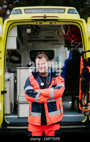 Porträt eines Arztes, der vor einem Krankenwagen steht. Stockfoto