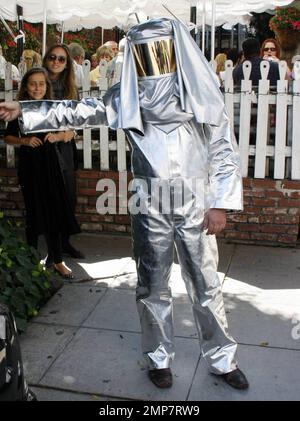 Der „Enourage“-Schauspieler Adrian Grenier geht mit einem Mann in einem Feueranzug spazieren und sieht sich einige Bilder auf einer Digitalkamera an, während er unterwegs auf den Straßen von Los Angeles dreht. Grenier, der kürzlich bei Tagesterminen mit dem Reality-TV-Star Kim Kardashian gesehen wurde, hat sich angeblich für einen Gastauftritt in der Teenager-Drama-Serie „90210“ angemeldet. Los Angeles, Kalifornien. 08/16/10. Stockfoto