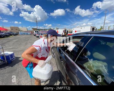 Fort Myers, FL (Okt 11, 2022) - Freiwillige des Roten Kreuzes verteilen Essen in einem Verteilzentrum, das auf dem Parkplatz der Cornerstone Ministries eingerichtet ist. Stockfoto