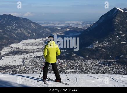 Garmisch Partenkirchen, Deutschland. 31. Januar 2023. Ein Skifahrer blickt von der Piste in das Loisach-Tal und auf die Häuser von Garmisch-Partenkirchen. Kredit: Angelika Warmuth/dpa/Alamy Live News Stockfoto