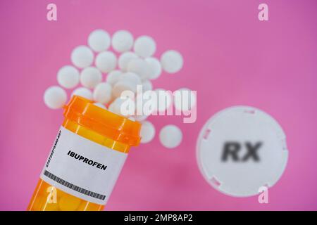 Ibuprofen Rx Arzneimittel-Pillen in Plazebo-Durchstechflasche mit Tabletten. Tabletten, die aus dem gelben Behälter auf rosa Hintergrund verschüttet werden. Stockfoto