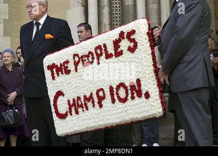 Die Trauernden tragen ein Schild mit der Aufschrift „The People's Champion“ auf der Snooker-Legende Alex „Hurricane“ Higgins' Beerdigung, die in der Kathedrale von Saint Anne stattfindet. Der zweimalige Weltmeisterin wurde letztes Wochenende nach einem langen Kampf gegen Krebs tot in seiner Wohnung in Belfast aufgefunden. Belftast, Irland. 8/2/10. . Stockfoto