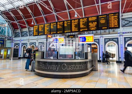 Kundeninformationsschalter und elektronische Abflugtafeln in der Haupthalle des Bahnhofs Paddington in London, Großbritannien Stockfoto