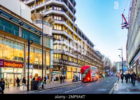 Am frühen Abend bietet sich ein Blick auf die Tottenham Court Road in London, Großbritannien, mit Lichtern von Geschäften und Büros, die die Szene beleuchten. Stockfoto