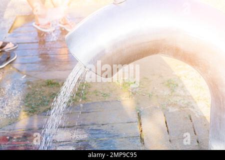 Ein Ort, um die Füße am Strand an sonnigen Tagen zu waschen. Wasserstrahl aus einem modernen großen Wasserhahn Stockfoto