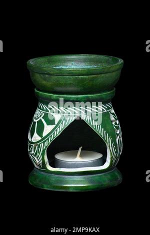 Bild einer grünen keramischen Aroma-Lampe mit Kerzen auf schwarzem Hintergrund Stockfoto