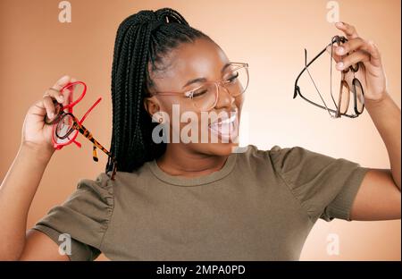 Aufgeregt, Brillenrahmen-Auswahl und schwarze Frau mit einem Lächeln von Augenpflege und Einzelhandelsprodukten. Studiohintergrund, isoliert und Schönheit eines jungen Studenten Stockfoto