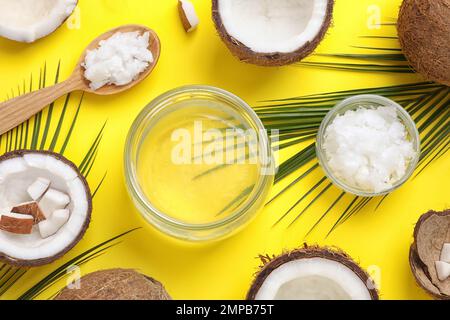 Flache Laienzusammensetzung mit Kokosöl auf gelbem Hintergrund Stockfoto