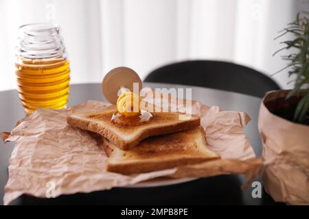 Köstlicher Honig und Toast auf dem schwarzen Tisch Stockfoto