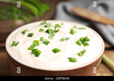 Frische Sauerrahm mit Zwiebeln in der Schüssel, Nahaufnahme Stockfoto