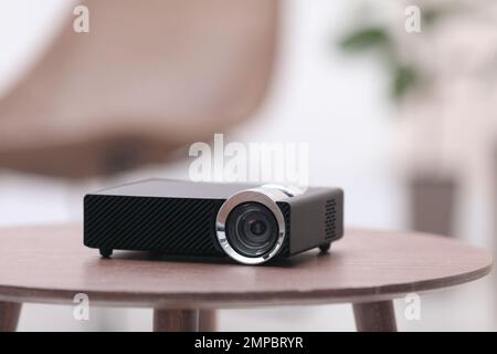 Moderner Videoprojektor auf Holztisch im Innenbereich Stockfoto