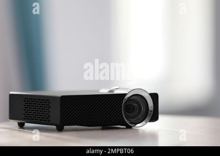 Moderner Videoprojektor auf weißem Tisch im Innenbereich. Platz für Text Stockfoto