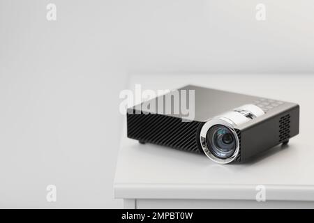 Moderner Videoprojektor auf weißem Tisch im Innenbereich. Platz für Text Stockfoto