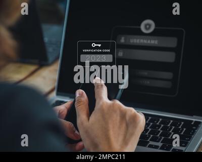 Zwei-Stufen-Authentifizierung (2FA) Konzept. 2023, Bestätigungscode und Schlüsselsymbol auf dem Smartphone während der Verwendung des Computers zur Passwortbestätigung, IDE Stockfoto
